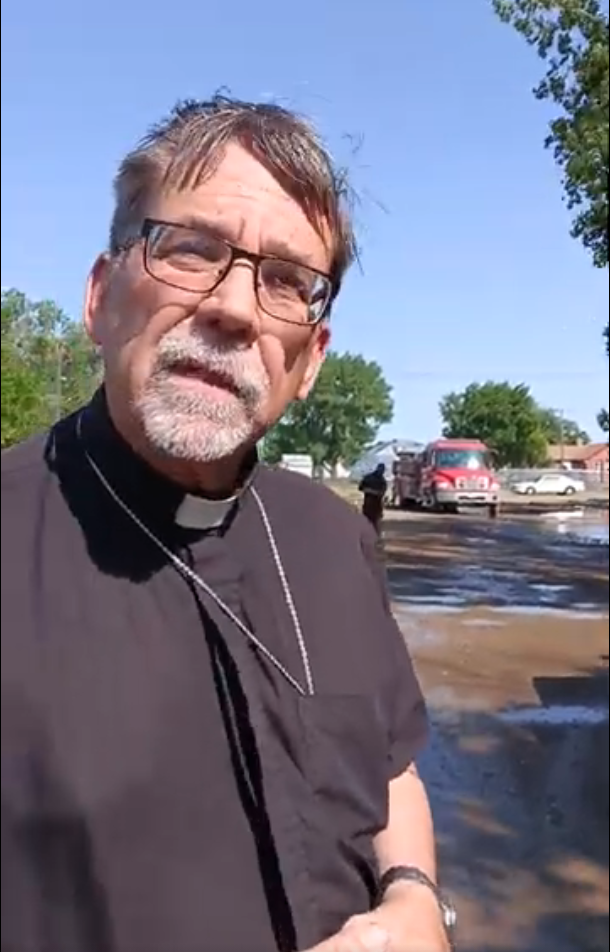 Bishop Jeffrey Fleming of the Diocese of Great Falls-Billings speaks near the scene of the Our Lady of Lourdes church fire in Poplar.